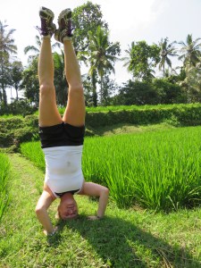 Kajta doing head stand in the rice field